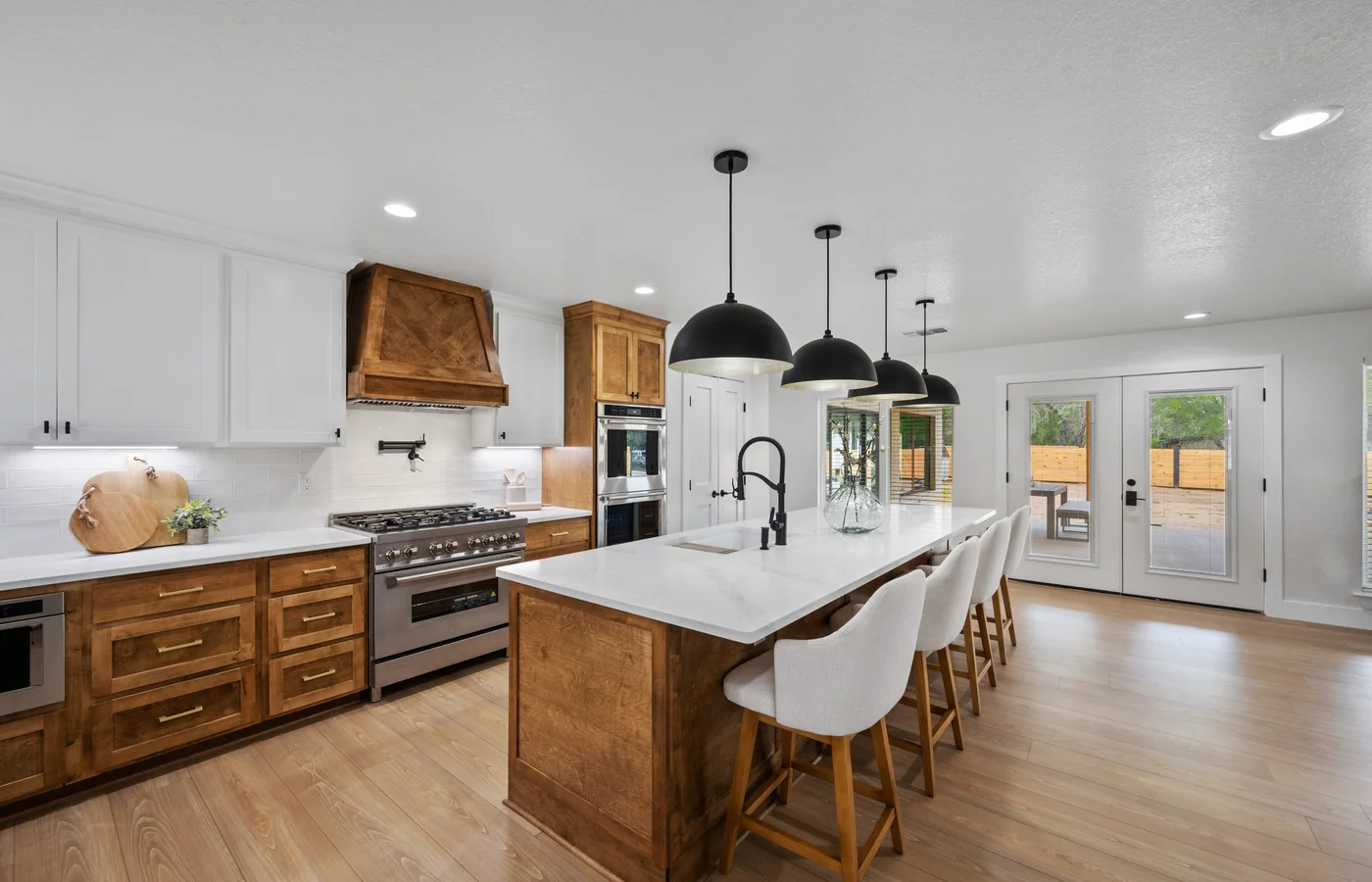 Updated farmhouse kitchen with a wood island, white quartz counters, and black pendant lights, move-in ready Georgia homes